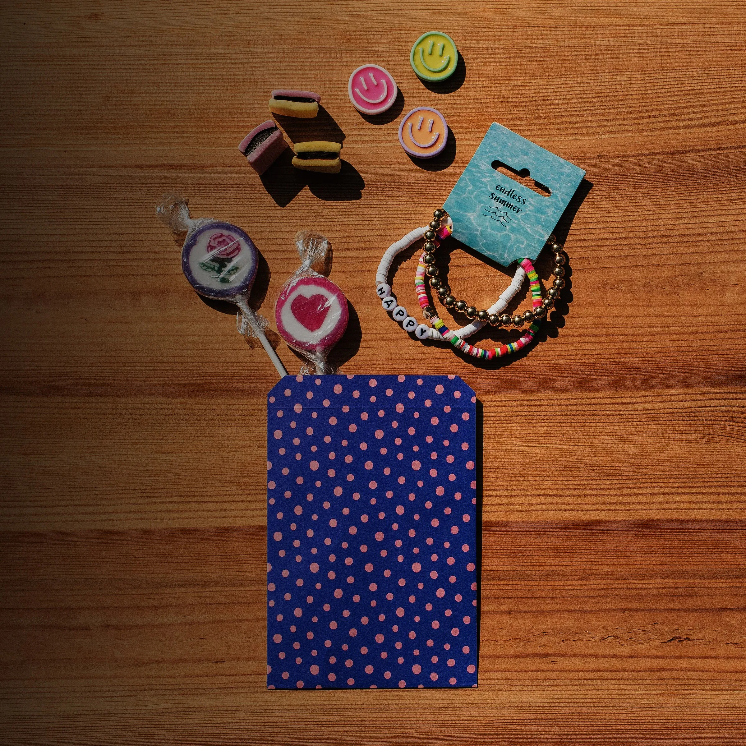 Gepunktetes Geschenktütchen mit Lutschern und Armbändern